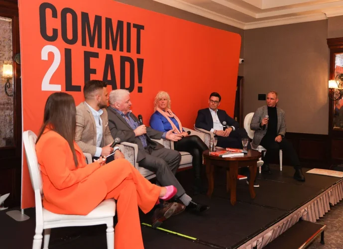 Panel discussion at Commit 2 Lead event with diverse speakers on stage.