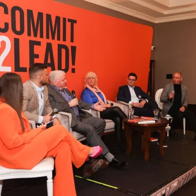 Panel discussion at Commit 2 Lead event with diverse speakers on stage.