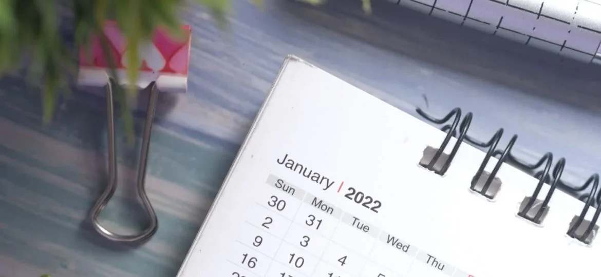 Close-up view of a desk calendar on January 2022 with a decorative paper clip, emphasizing planning and time management.