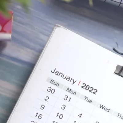 Close-up view of a desk calendar on January 2022 with a decorative paper clip, emphasizing planning and time management.