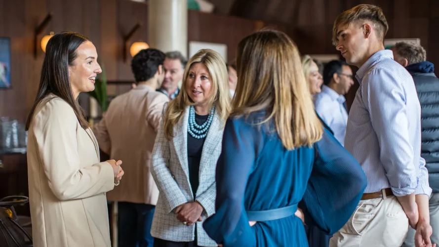 Business professionals networking and talking at a café event.