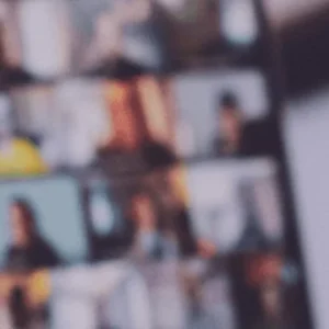 Blurred background of a laptop screen displaying a virtual meeting with multiple participants, symbolizing remote collaboration.