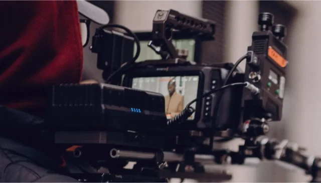 Film production scene showing a camera focusing on a subject in a studio.