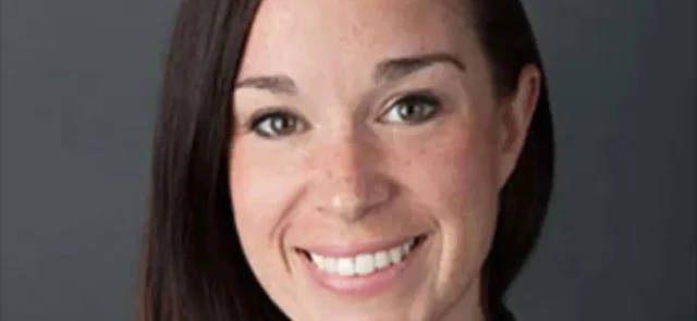 Headshot of Katrina Steady, smiling, with straight dark hair, against a plain background.