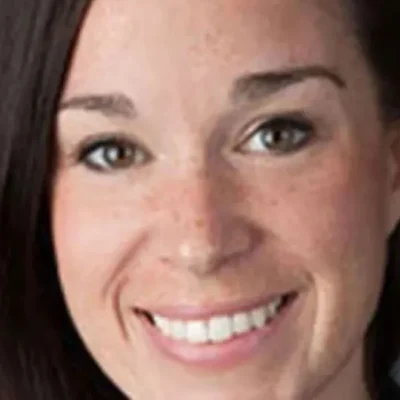 Headshot of Katrina Steady, smiling, with straight dark hair, against a plain background.