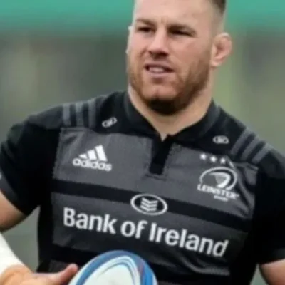 Rugby player Sean O'Brien holding a rugby ball, wearing a black Bank of Ireland jersey during a practice session.