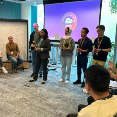 Group of AWS APAC leaders and McNulty Performance team during a leadership development session, with participants engaged and receiving awards in a workshop setting.